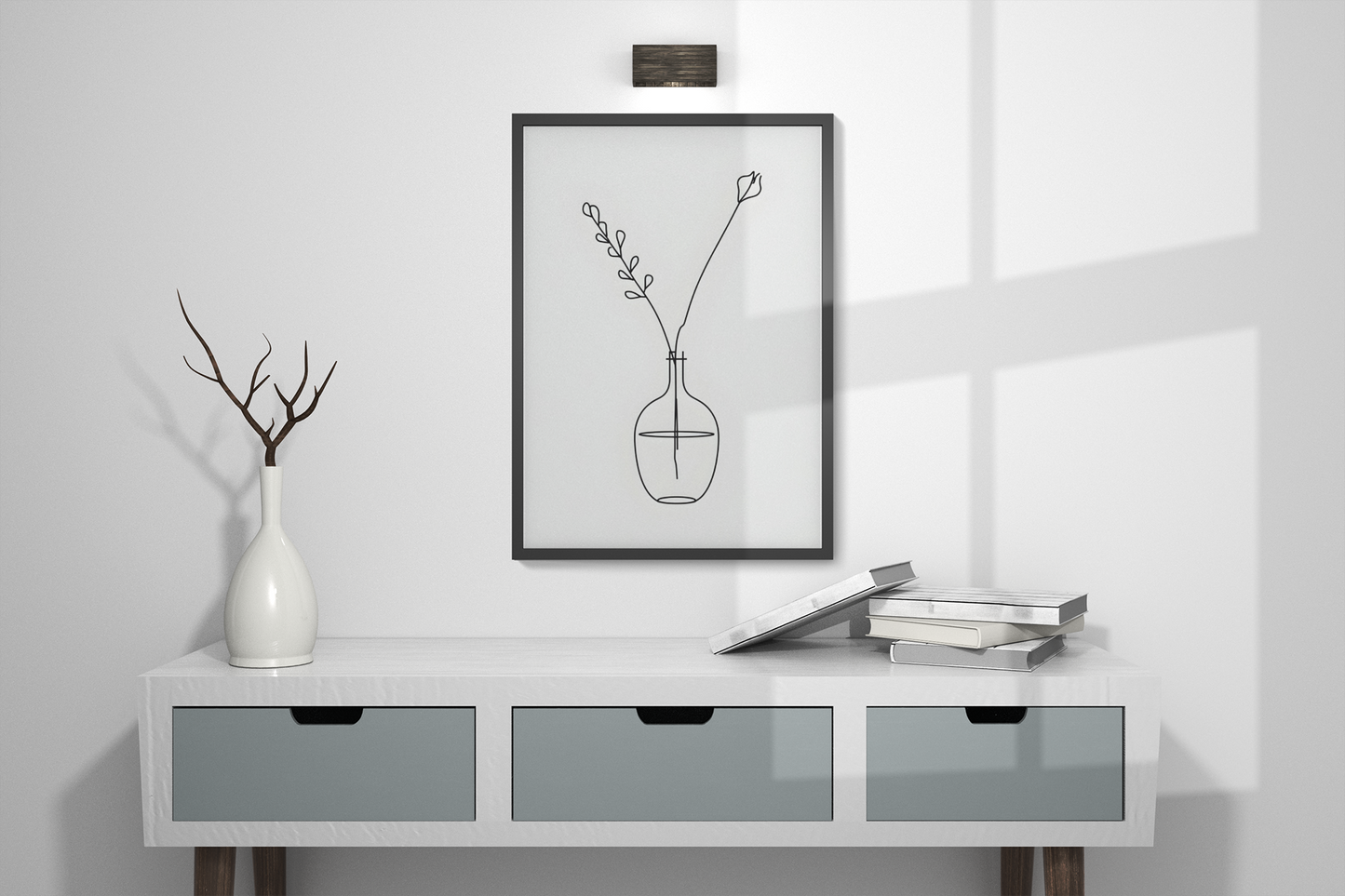 Modern interior with a white console table, vase, and framed artwork on a light gray wall.