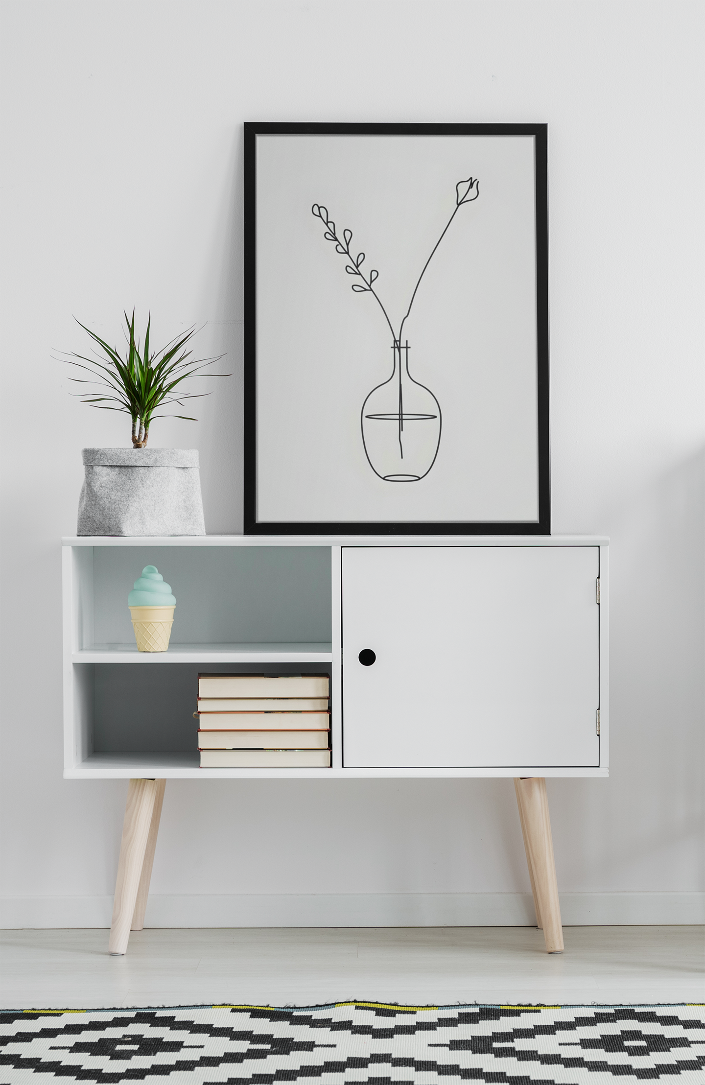Modern interior with a white cabinet, framed artwork, and decorative items.