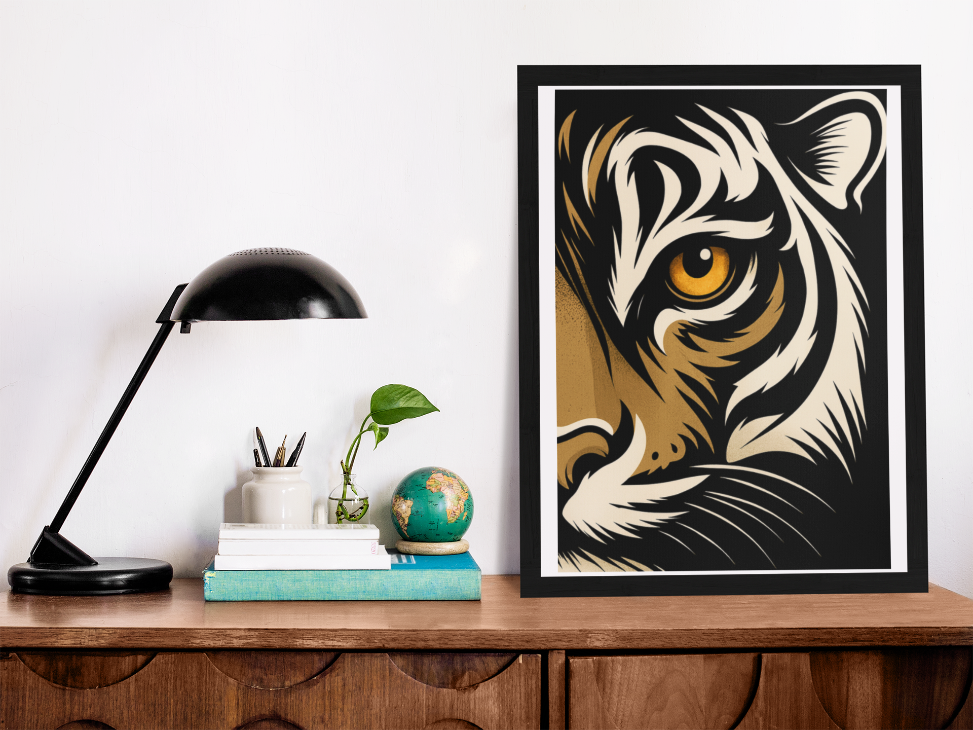 Framed tiger artwork on a wooden surface with a lamp and books in the background.