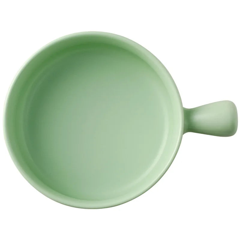 Green ceramic mug with handle on a white background