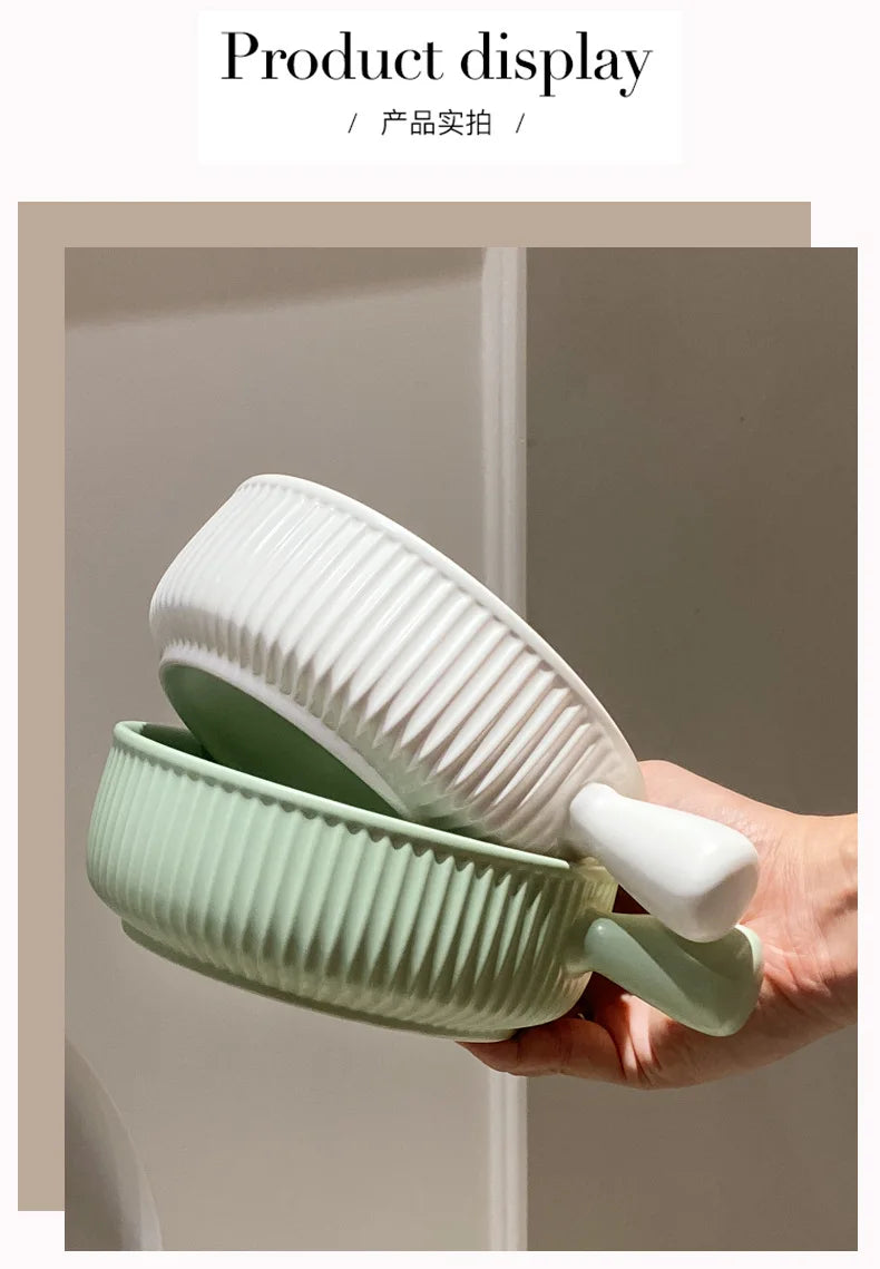 Hand holding a green and white ceramic bowl with lid against a neutral background