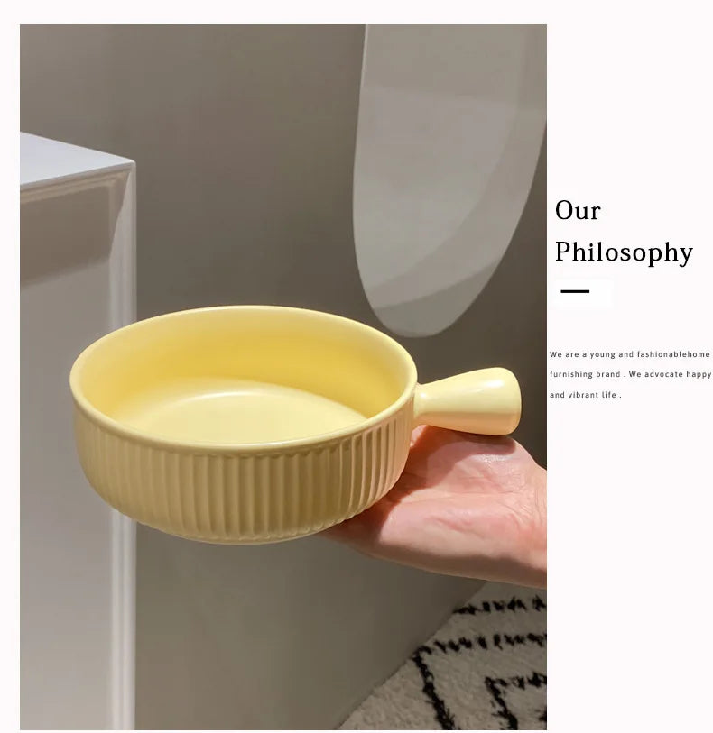 Yellow ceramic cup held by a hand with a neutral background