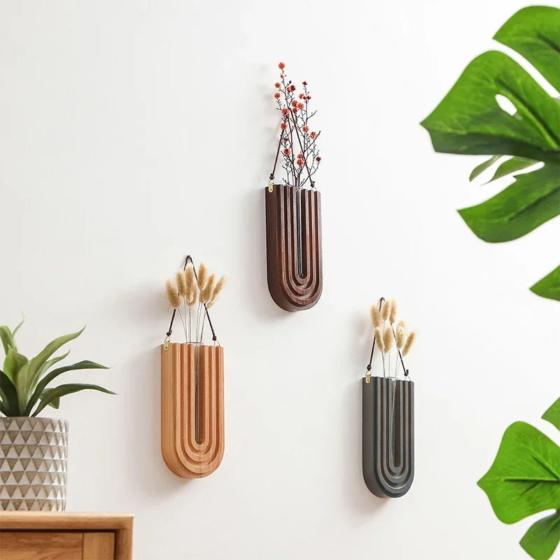 Three wall-mounted planters with different designs on a light background