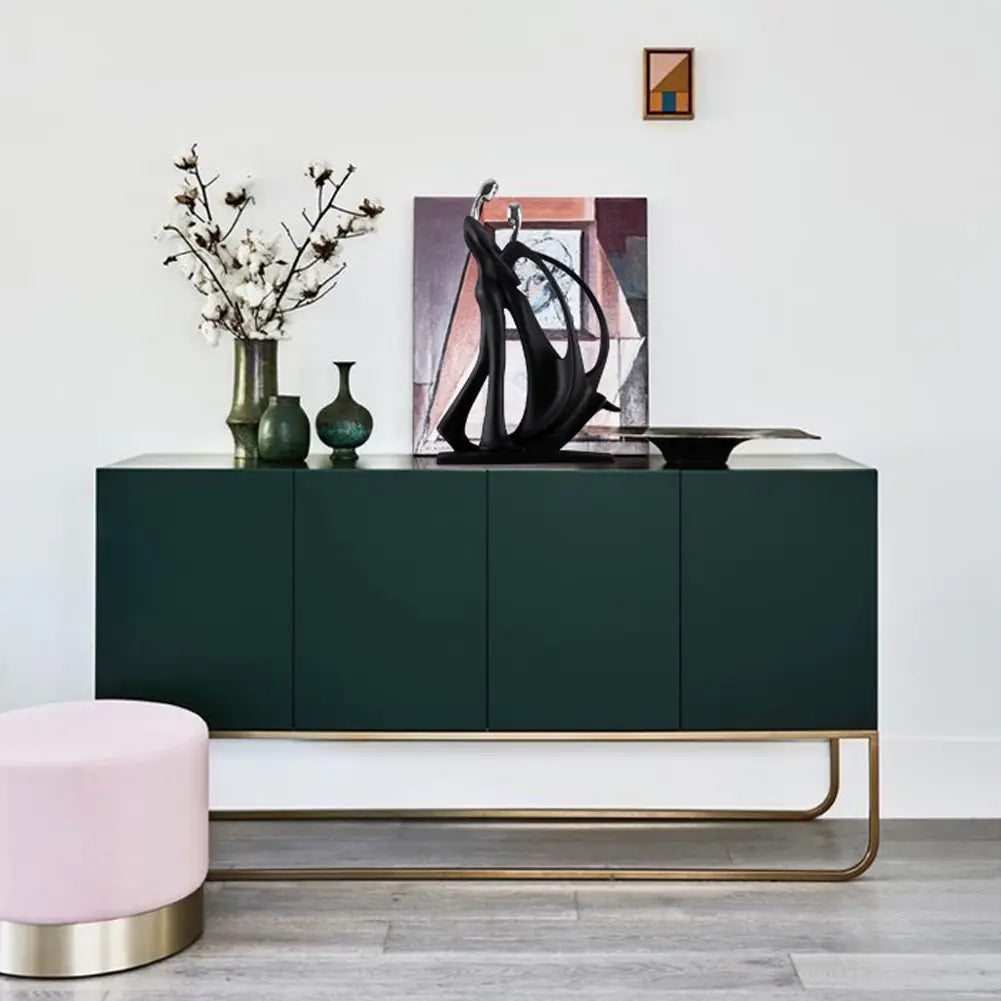 Modern green sideboard with gold legs in a room setting.