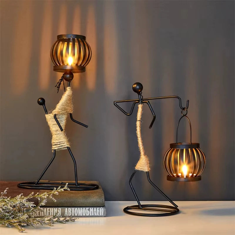 Two decorative lamps shaped like people with woven bodies and metal legs on a neutral background.