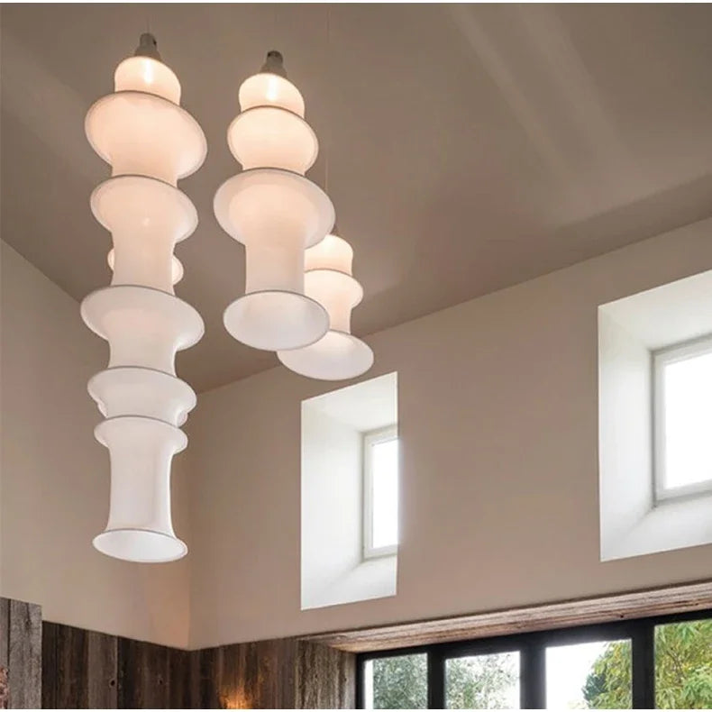Modern chandelier hanging in a room with large windows