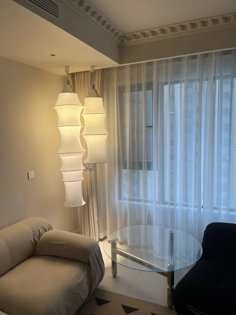 Modern living room with a stylish lamp, sofa, and glass coffee table.