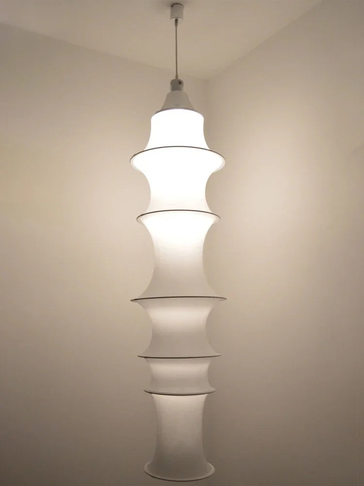 Modern pendant light with tiered design against a plain wall