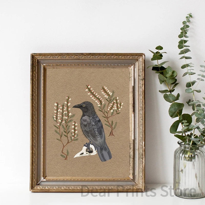 Framed artwork of a crow and floral elements on a beige background, next to a vase with greenery.