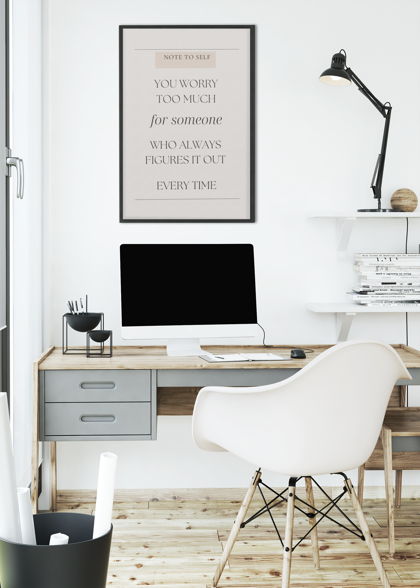 Modern home office with a desk, chair, computer monitor, and framed quote on the wall.