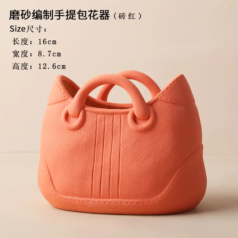 Pink handbag-shaped flower pot with dimensions on a beige background