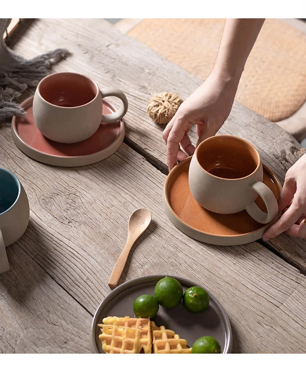 Ceramic mugs on wooden table with waffles and limes