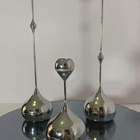 Video of a Set of three luxury waterdrop metal candle holders in silver displayed on a table  