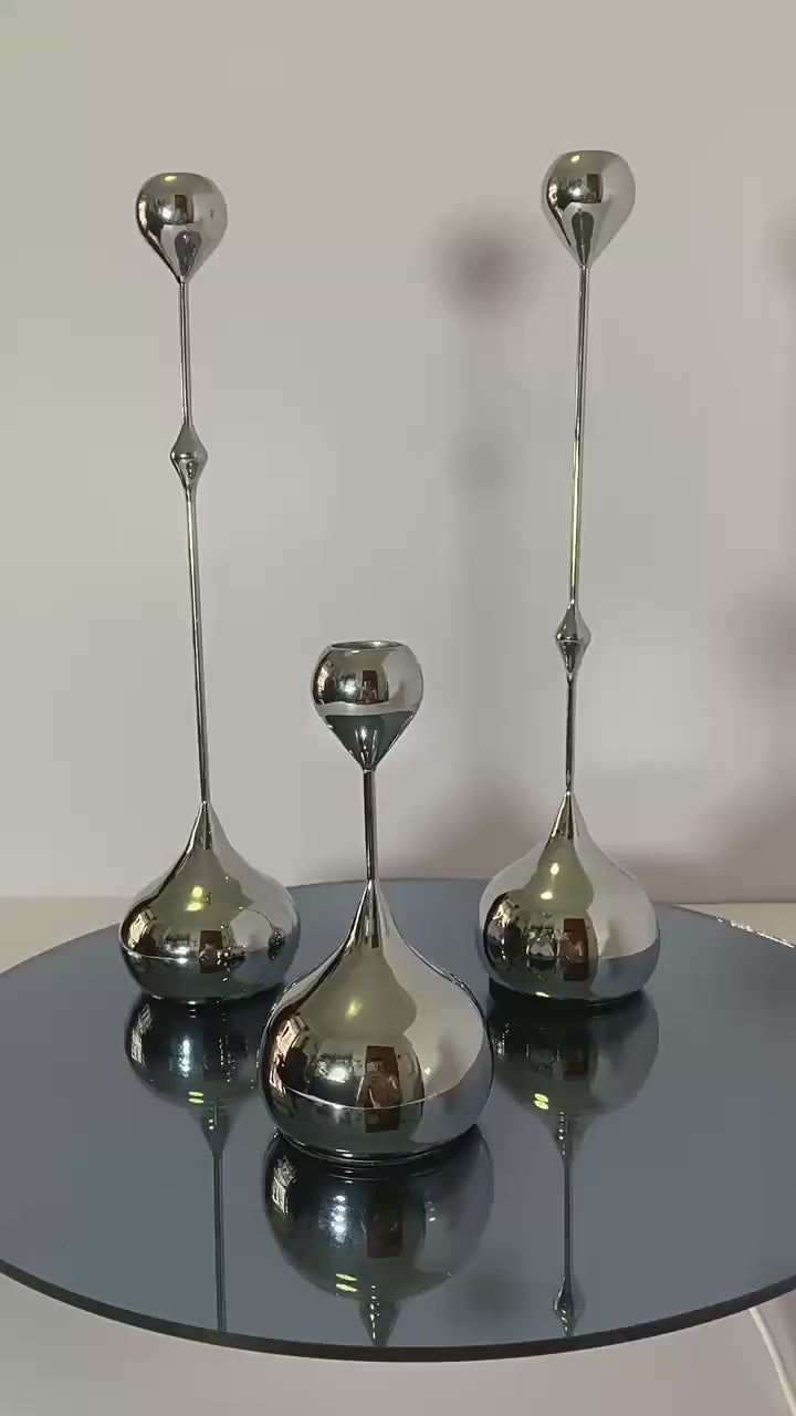 Video of a Set of three luxury waterdrop metal candle holders in silver displayed on a table  
