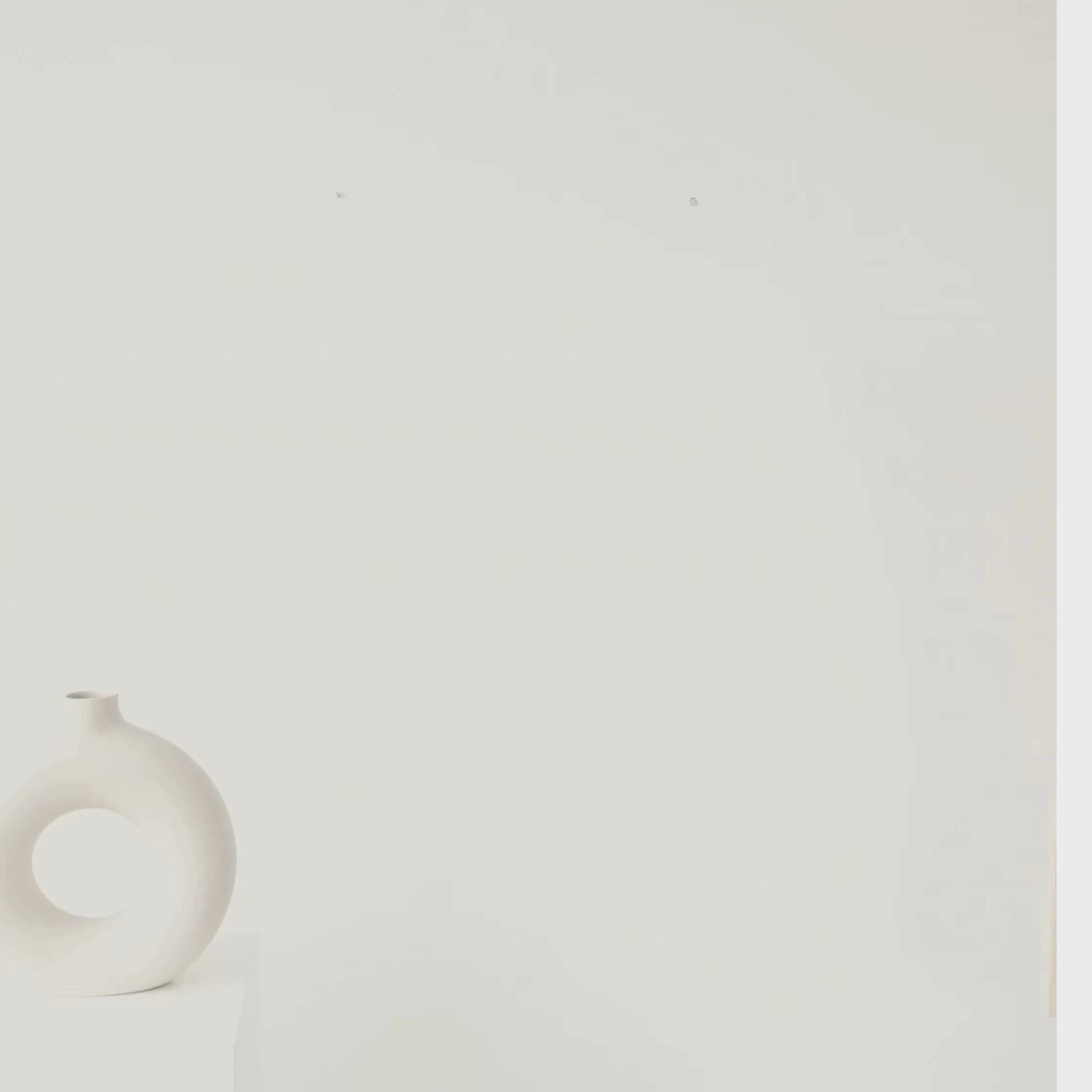 Woman hanging the Amplified scientific sound wave poster in a modern home, showcasing minimalist speaker artwork with striking electric blue accents.