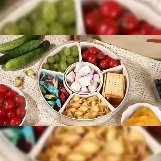 Video of a Rotating clear Snackle Box serving tray with divided compartments for fruit, nuts, sweets, vegetables and party snacks 