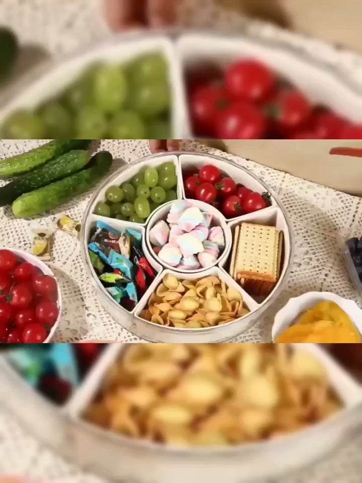 Video of a Rotating clear Snackle Box serving tray with divided compartments for fruit, nuts, sweets, vegetables and party snacks 