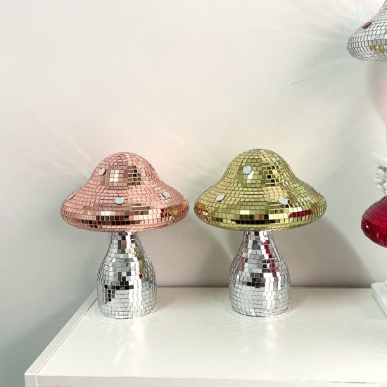 Video of mushroom ornaments with mirrored mosaic tiles and silver reflective stems displayed on a shelf