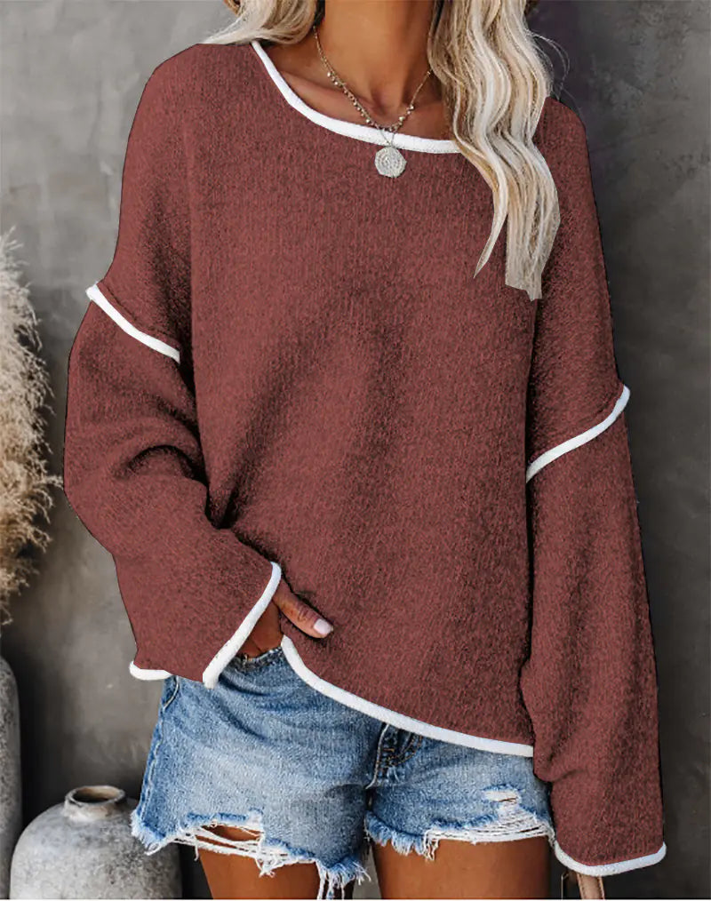 Person wearing a maroon sweater with white trim and denim shorts against a gray background