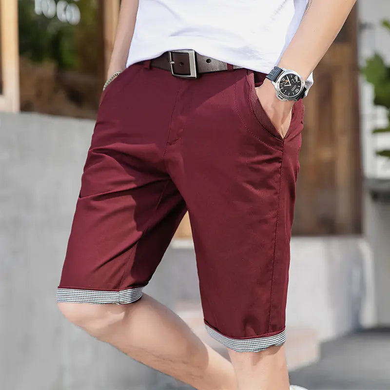 A pair of burgandy men's casual sports shorts with a mid-waist fit  on a whote background