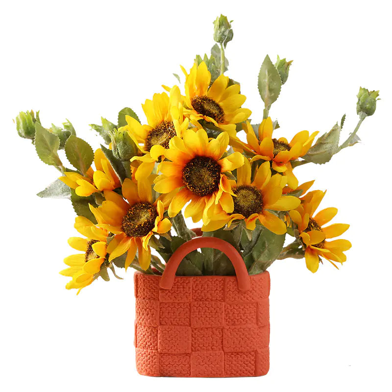 Bouquet of sunflowers in a textured orange basket on a white background