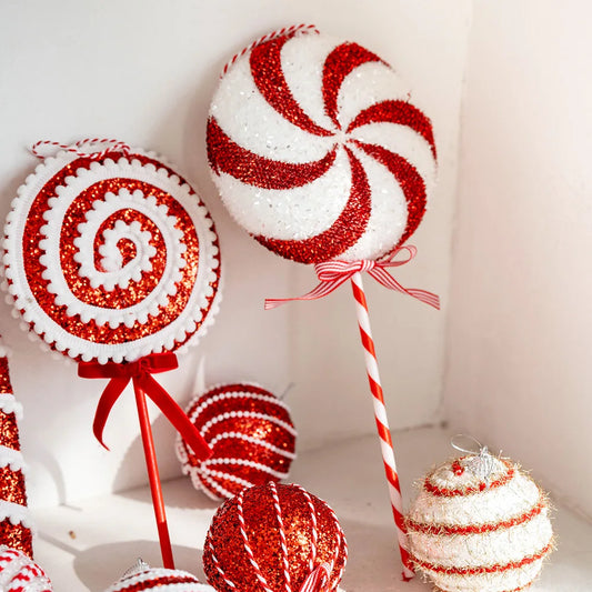 Decorative candy-themed ornaments including lollipops and peppermints on a white background.