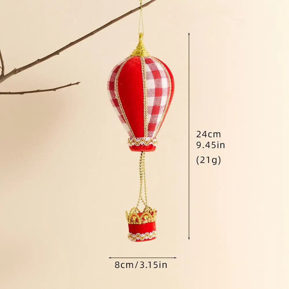 Red hot air balloon ornament with gold accents on a beige background