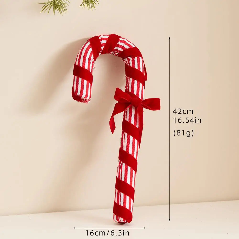 Red and white striped candy cane-shaped toy with a bow on a beige background, showing measurements.