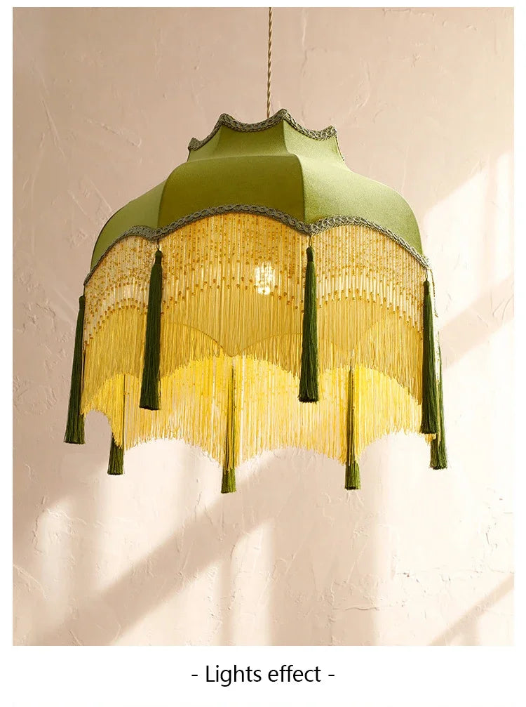 Green lampshade with fringe details on a textured wall background