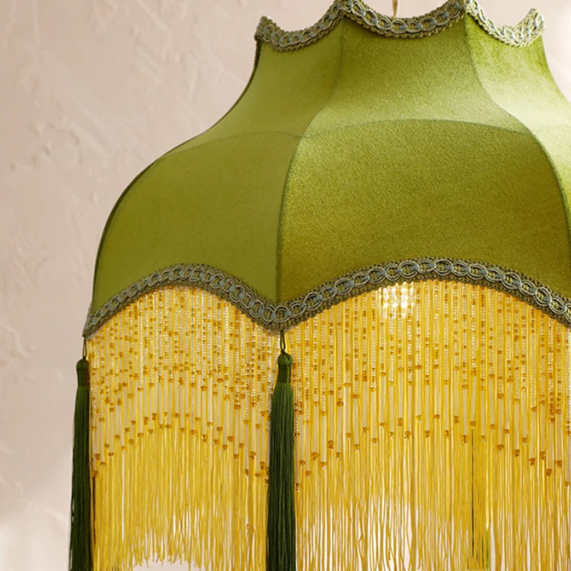 Green and yellow lampshade with tassels on a beige background