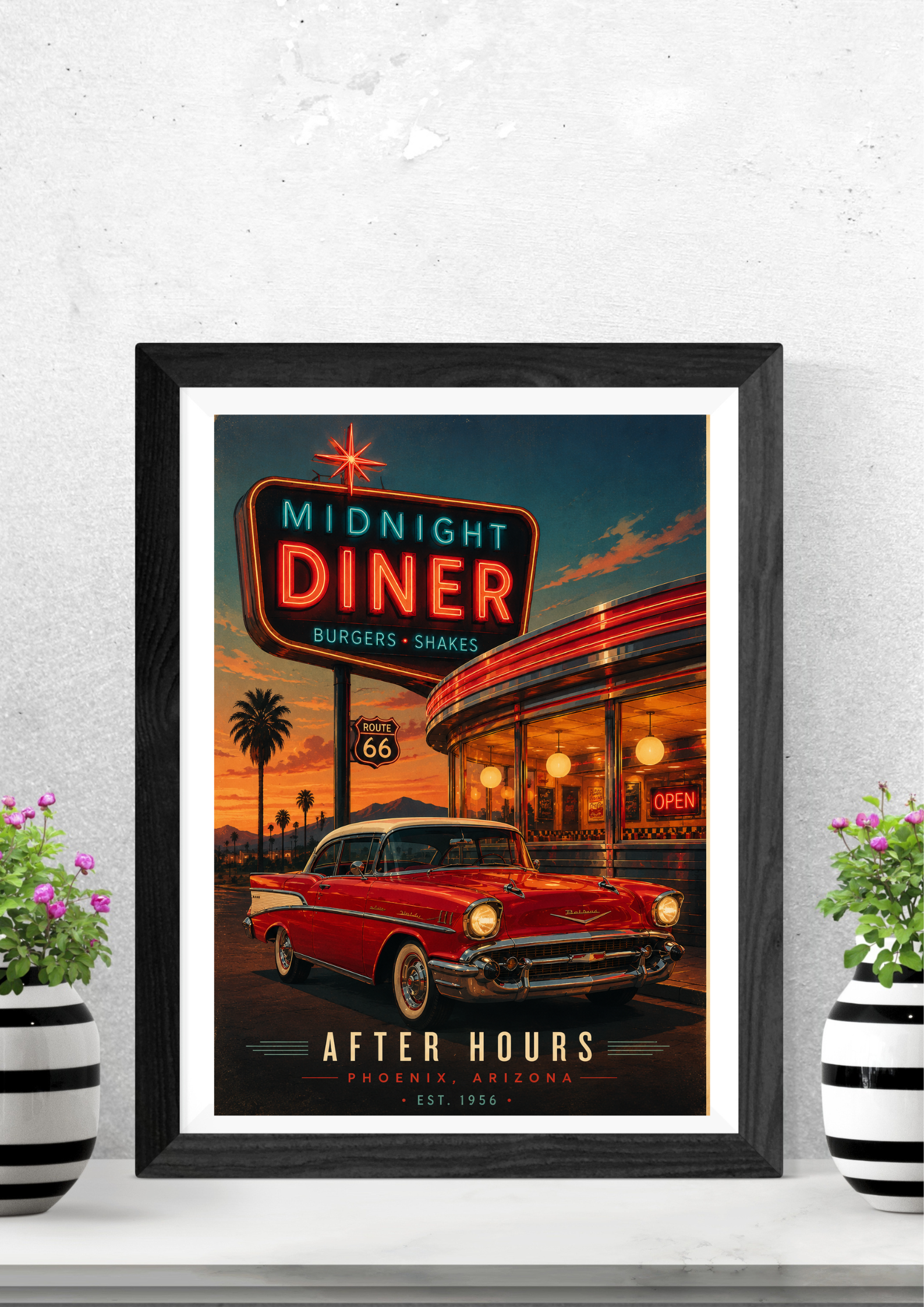 Framed poster of a diner with a red car and neon sign on a white wall.