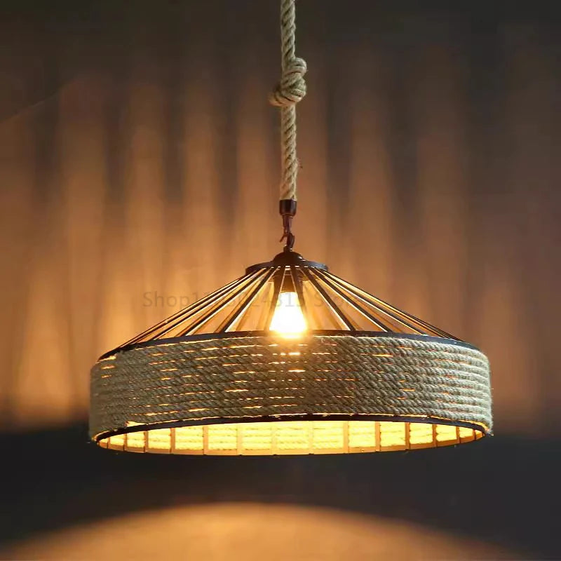 Rustic hemp rope pendant light with industrial metal frame and warm LED bulb, ideal for dining room or café decor.