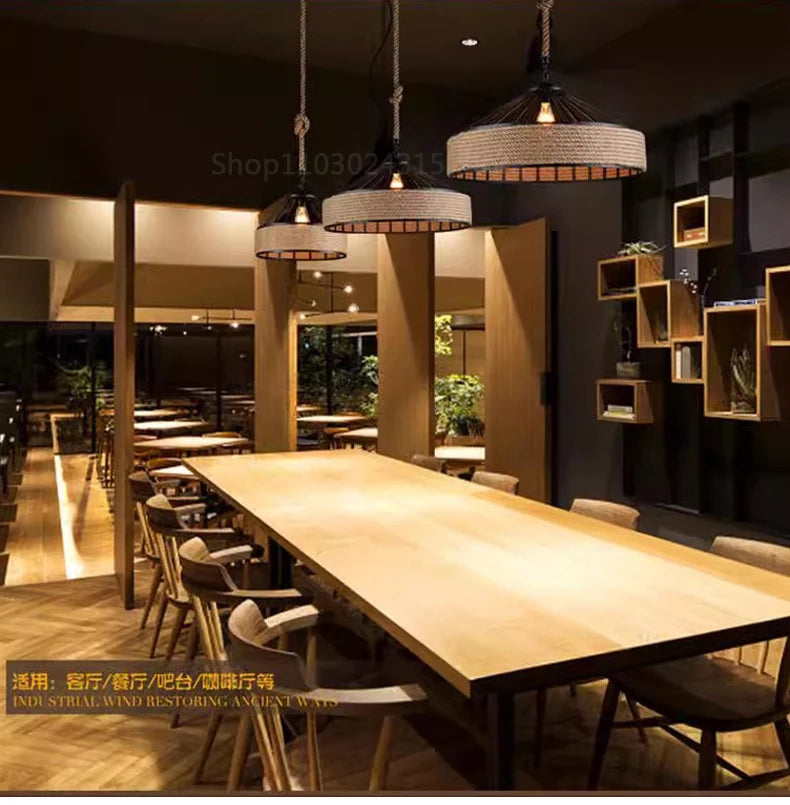 Modern dining area with wooden table and chairs, illuminated by pendant lights.