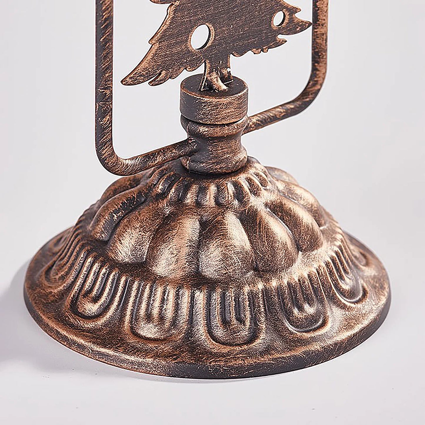 Bronze oil lamp with intricate design on a white background