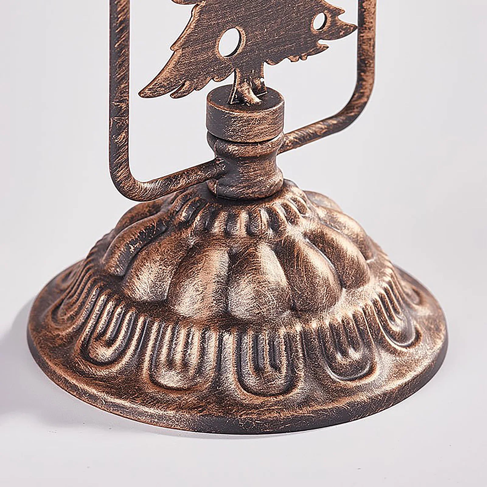 Bronze oil lamp with intricate design on a white background