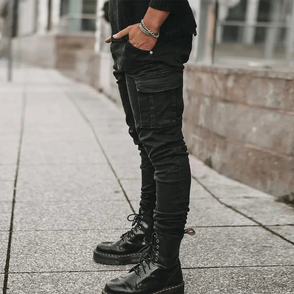 Person wearing black cargo pants and boots on a sidewalk.