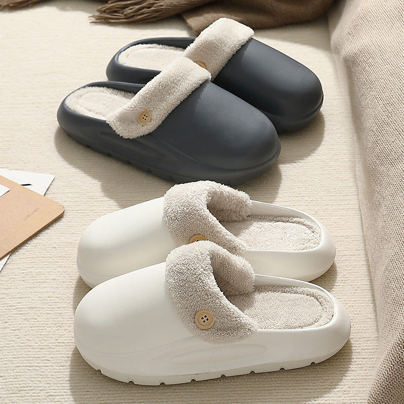 Pair of gray and white slippers with fuzzy lining on a beige surface