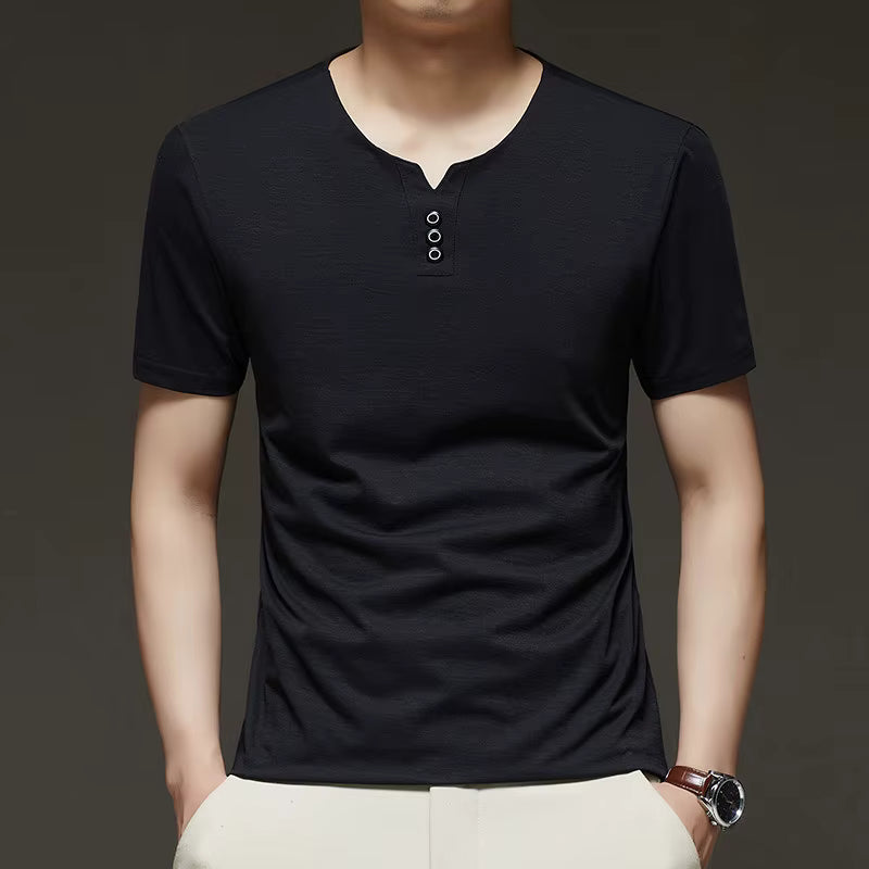 Person wearing a black short-sleeve henley shirt with a plain background