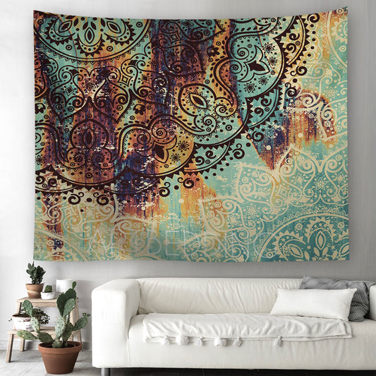 Colorful tapestry with intricate patterns hanging above a white sofa in a living room.