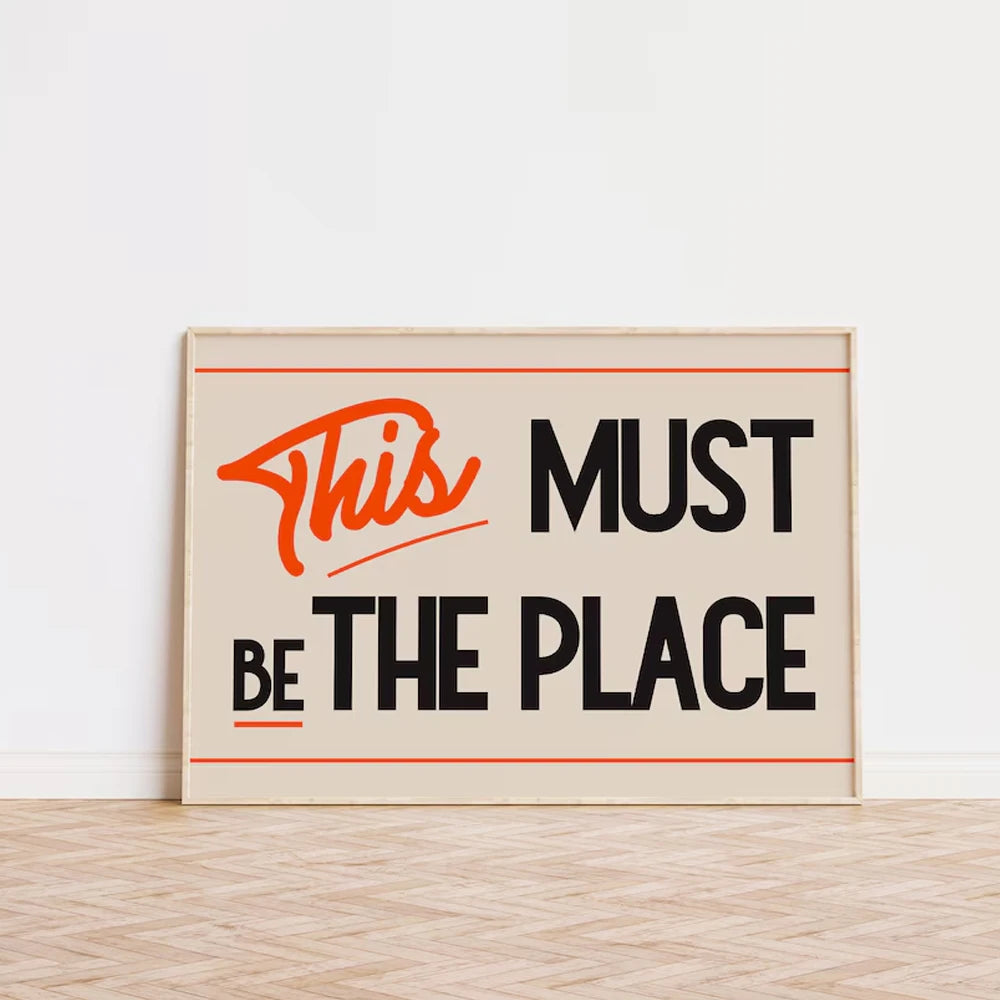 Framed poster with motivational quote 'This Must Be The Place' on a light background