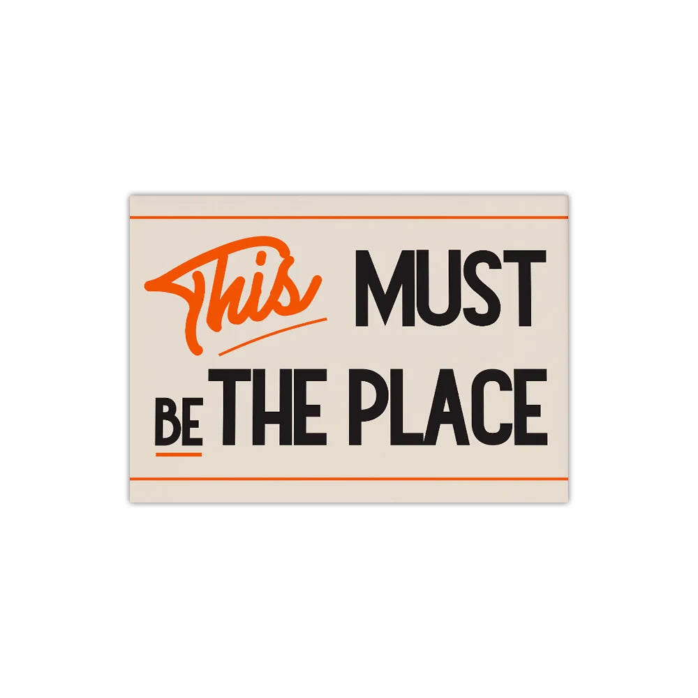 Rectangular sign with text 'This MUST be THE PLACE' on a beige background