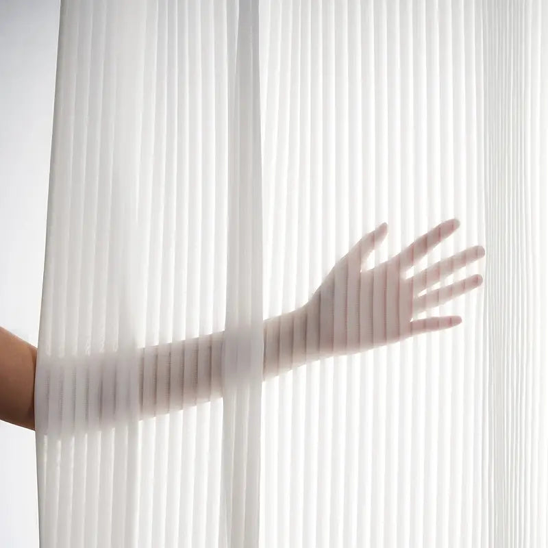 A hand behind a white curtain background