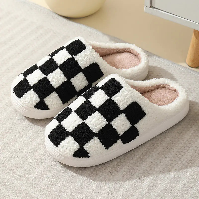 A pair of checkered cotton slippers in blue and a pair in red, displayed in front of a neutral background.