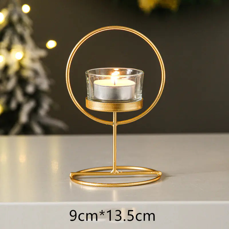 Gold candle holder with a lit candle on a neutral background