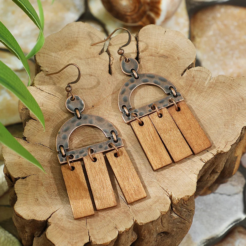 Wooden earrings with metal accents on a wooden surface