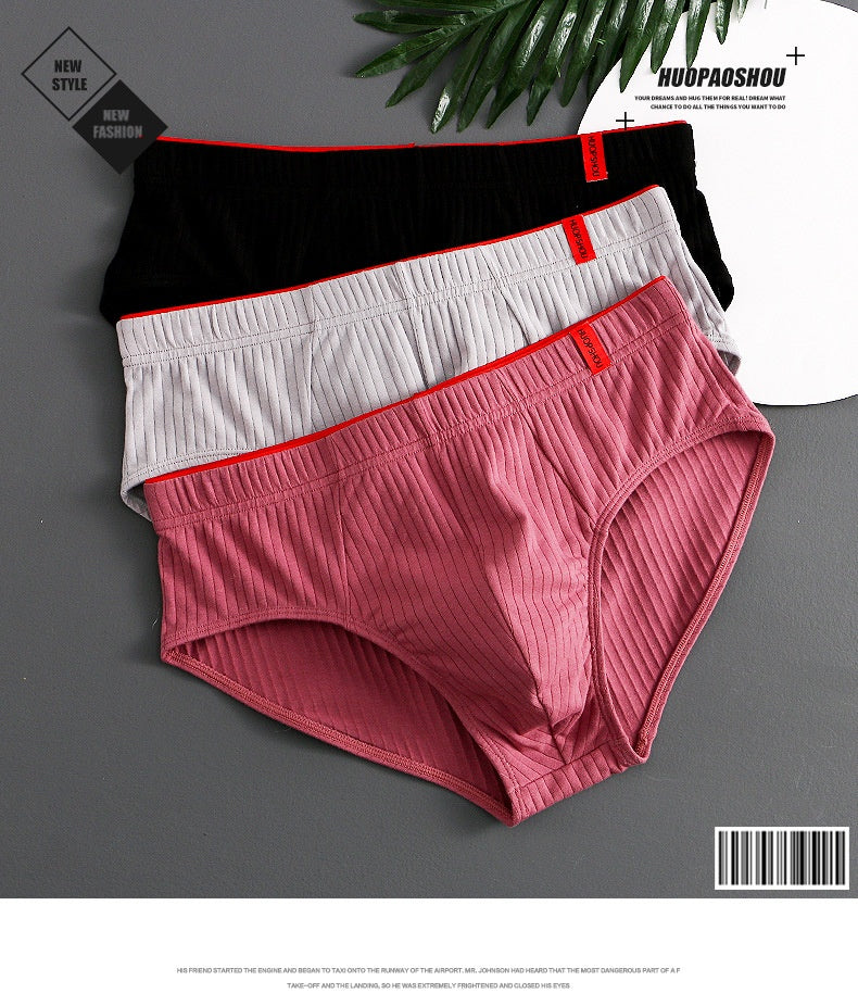 Three pairs of men's underwear in black, white, and red on a gray background.