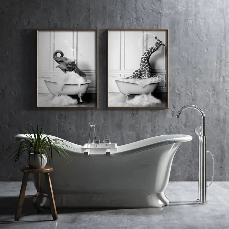 Bathroom interior with a freestanding bathtub, framed artwork of an elephant and giraffe in a bathtub, and a plant on a stool.