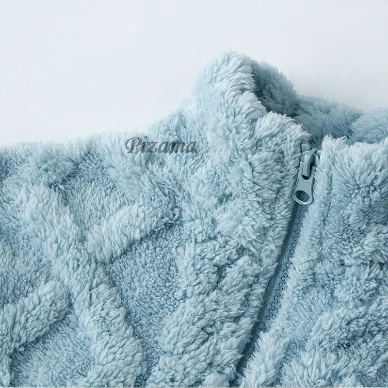 Close-up of a fluffy blue garment with a zipper, featuring the brand 'Pizama'.