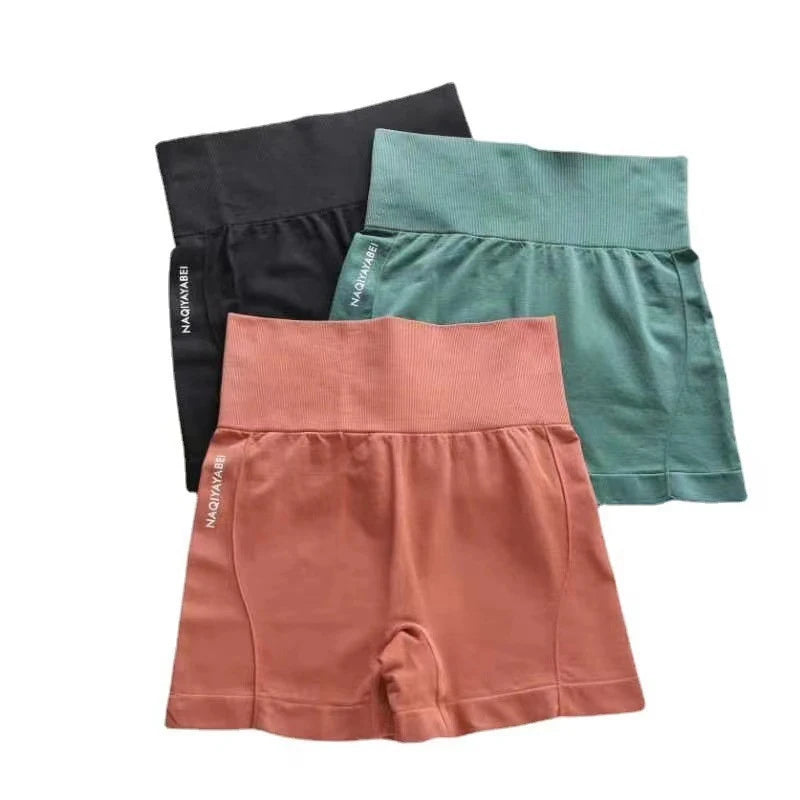 Three pairs of shorts in black, green, and pink on a white background