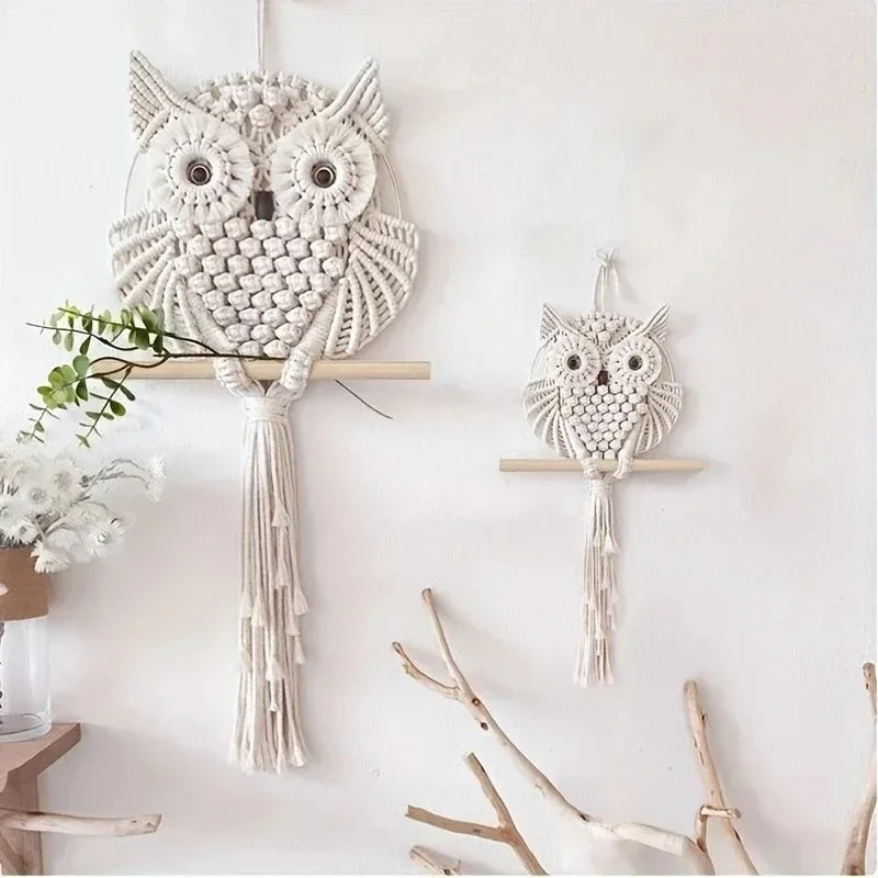 Two macrame owl wall hangings on a white wall with minimal decor.